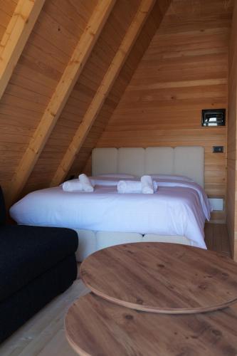 een slaapkamer met een bed op zolder met een tafel bij United Villas in Pogradec