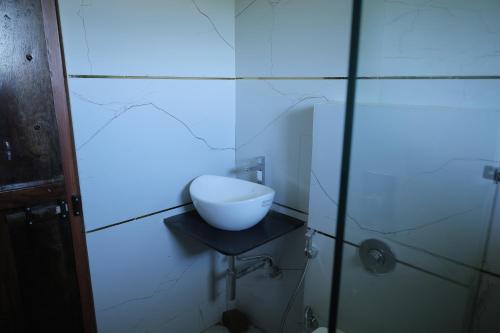 ein Badezimmer mit einer Schüssel auf einem Tisch in der Wand in der Unterkunft Chandra Bagh in Māvli