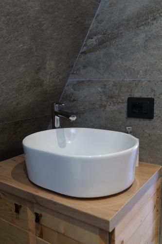 een witte wastafel op een houten aanrecht in een badkamer bij United Villas in Pogradec