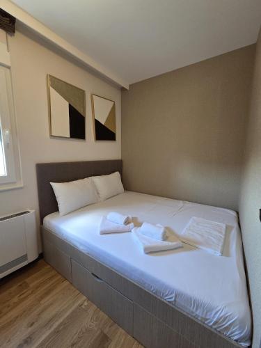 a bed in a room with two towels on it at Dukk in Belgrade