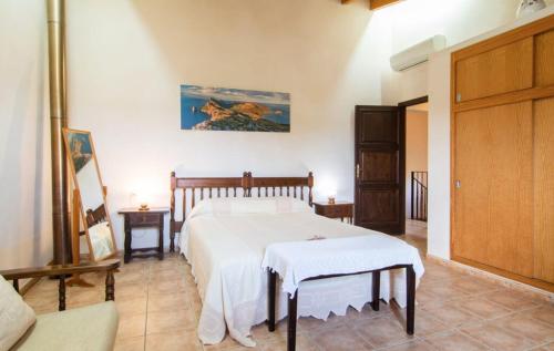 een slaapkamer met een bed met een witte sprei bij Villa Sa Mata in Campanet