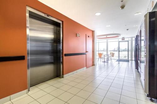 an office hallway with a metal door and orange walls at Motel 6-Kingston, ON in Kingston
