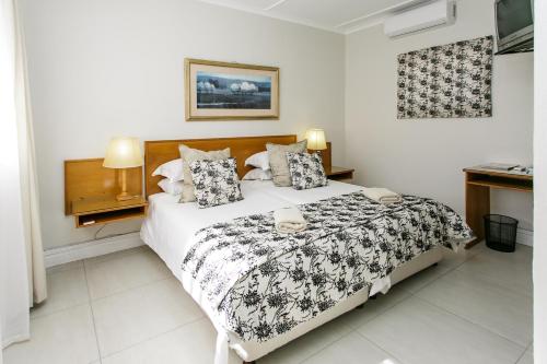 a bedroom with a bed with a black and white comforter at Wagon Wheel Country Lodge in Beaufort West