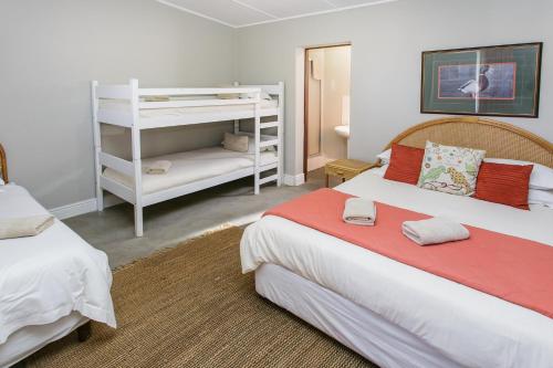 a bedroom with two beds and a book shelf at Wagon Wheel Country Lodge in Beaufort West