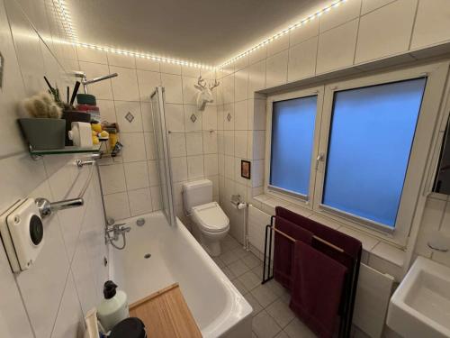 een badkamer met een bad, een toilet en een wastafel bij Centurio 5 in Baselaugst
