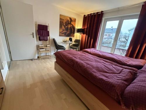 een slaapkamer met een bed, een bureau en een raam bij Centurio 5 in Baselaugst