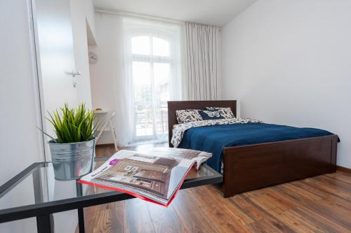 1 dormitorio con cama y mesa de cristal en Apartamenty Zamulkowa 4TWO, en Katowice