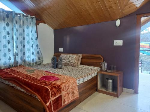 a bedroom with a bed and a blue wall at Happy Mountains in Nārkanda
