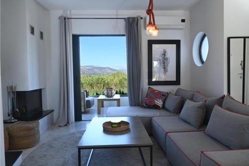 a living room with a couch and a tv at Hydra House Nafplio in Myloi