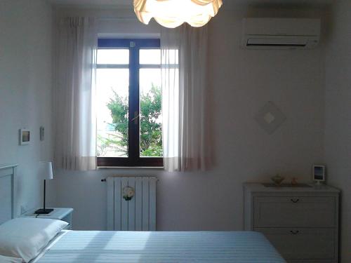 a bedroom with a bed and a window at Bed And Breakfast Catherina in Ponsacco