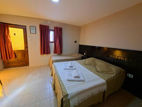 a hotel room with two beds and a window at Hosteria Marina Bella 2 in Rada Tilly