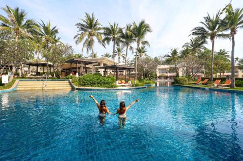 two girls swimming in a pool at a resort at Sheraton Hua Hin Resort & Spa in Cha Am