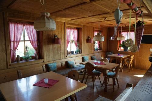 a dining room with tables and chairs and windows at Hotel Sonnenbichl in Halblech