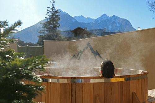 a person is in a hot tub with steam at Garrigae Caserne de Briançon & SPA Cinq Mondes in Briançon
