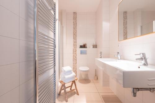een witte badkamer met een wastafel en een toilet bij Hotel het Oude Raadhuis in Castricum