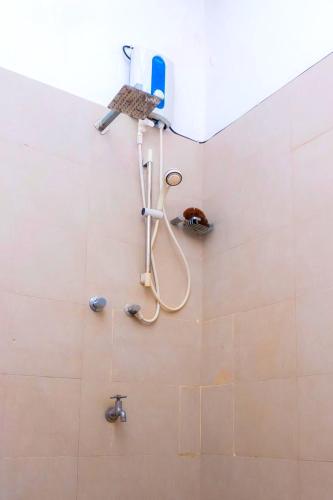 a shower with a hose attached to a wall at Bentota Backpackers Bay Hostel in Bentota