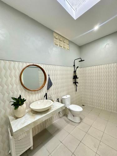 a bathroom with a sink and a toilet and a mirror at New Mekar Jaya Hotel in Legian