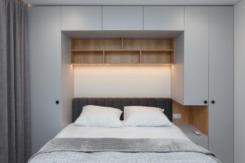 a bedroom with a large bed with white walls at HomeRent Petru Zadnipru in Chişinău