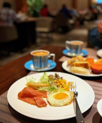 中卫大乐之野（中卫黄河宿集店）的桌子上摆着几盘早餐食物和两杯咖啡。