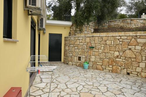 a stone wall with a chair in front of a building at Sivota Apartments in Sivota