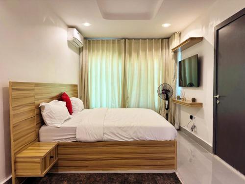 a bedroom with a large bed with a window at The Colony in Mama
