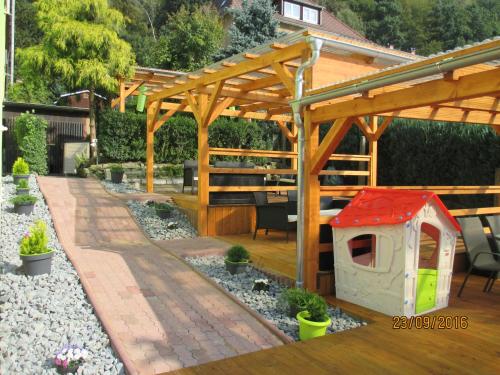 einen Hinterhof mit einer hölzernen Pergola und einem Hundehaus in der Unterkunft Villa Arizona in Bad Schandau