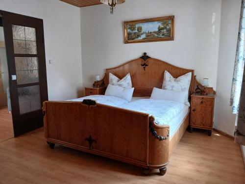 ein Schlafzimmer mit einem großen Holzbett mit weißen Kissen in der Unterkunft Kutscherhaus Werdau in Werdau