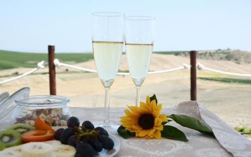 two glasses of white wine next to a plate of food at RE UMBERTO b&b - Suite di charme e Country rooms in San Salvo