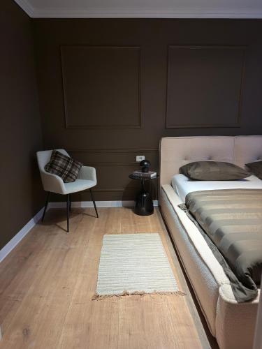 a bedroom with a bed and a chair and a rug at Cozy Central View -Self Check-In 24h in Reşiţa
