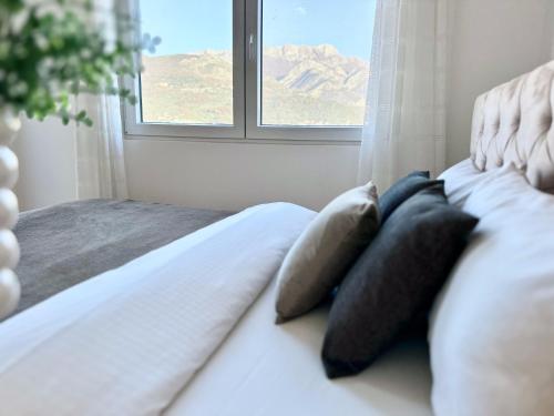 een slaapkamer met een bed met kussens en een raam bij Alula Apartments in Bar
