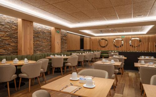 een eetkamer met tafels, stoelen en spiegels bij Hotel Montarto in Baqueira-Beret