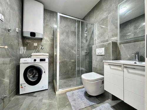een badkamer met wasmachine en toilet bij Alula Apartments in Bar