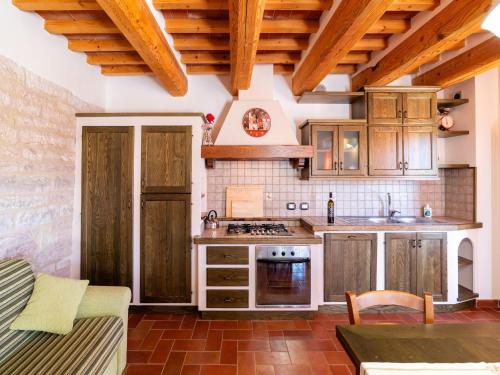 een keuken met houten kasten en een kookplaat met oven bij Apartment in a farmhouse with 2 swimming pools in Cagli
