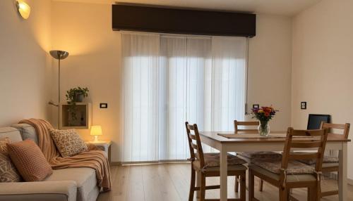 a living room with a table and a couch at Carbonera 4 - casetta vicina alla Stazione in Tirano
