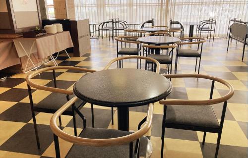 a group of tables and chairs in a room at 寝屋川トレンドホテル in Neyagawa
