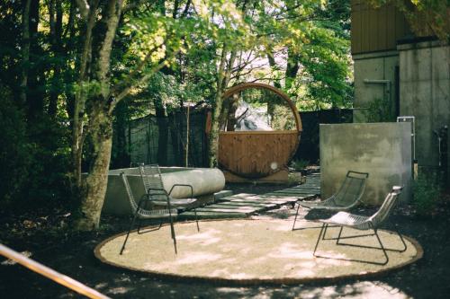 a yard with two chairs and a large mirror at ヴィヒタ 山中湖 in Yamanakako