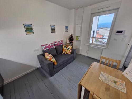 ein Wohnzimmer mit Sofa und Tisch in der Unterkunft Appartement F2 5B in Martres-de-Veyre