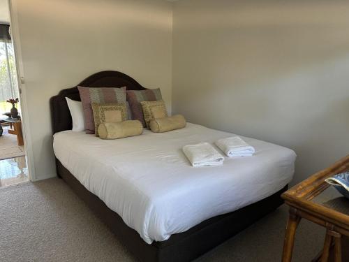een slaapkamer met een bed met witte lakens en kussens bij Kiama Downs Oasis with Pool, Spa & Sauna in Kiama Downs