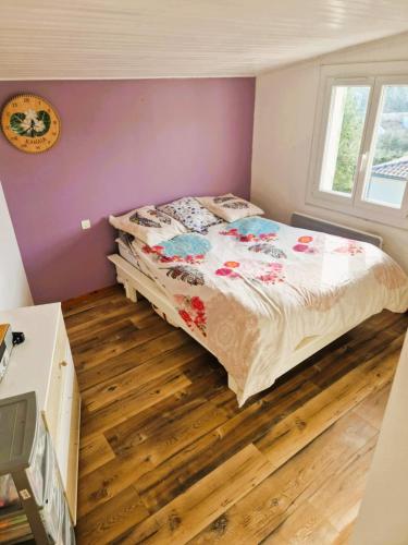 a bedroom with a bed and a wooden floor at Maison TIKI TAHITI in Alès
