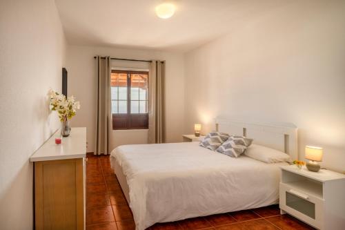 a bedroom with a white bed and a window at CHL Serycam Breña Baja, infinity views in Breña Baja