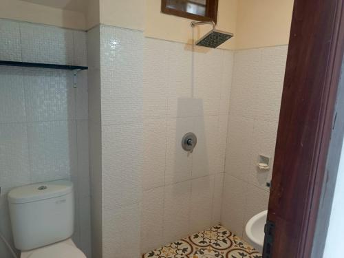 a small bathroom with a toilet and a sink at Rumah Ramah Ubud in Ubud