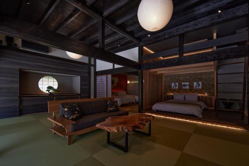 a bedroom with a bed and a couch in a room at えにし美山 霞月 -kagetsu- in Nantan city