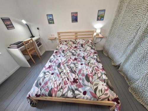 een slaapkamer met een bed met een bloemenbed bij Appartement F2 5A in Martres-de-Veyre