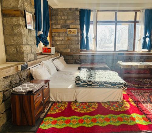 een slaapkamer met twee bedden en een raam bij High on hills in Kalgha
