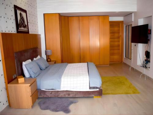 a bedroom with a large bed and a television at Villa Les Ambassades in Kenitra