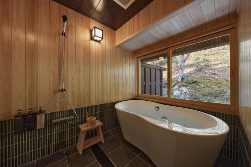a bath tub in a bathroom with a window at えにし美山 霞月 -kagetsu- in Nantan city