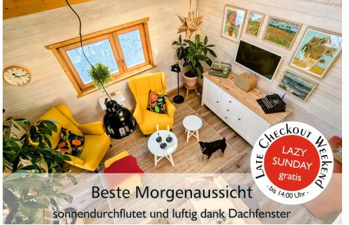 ArnoldshammerWichtelhaisl Rittersgrün im Erzgebirge - Entspannen im fröhlichen Tiny House - umzäunter Naturgarten-Hunde willkommen-Ebike und Elektroauto laden的享有带黄色家具的客厅的顶部景色。