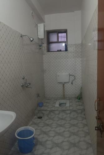 a bathroom with a toilet and a sink and a window at Vishwanathan in Varanasi