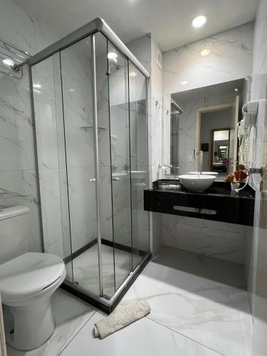 a bathroom with a shower and a toilet and a sink at Ponta Negra Beach Melo Flat in Natal