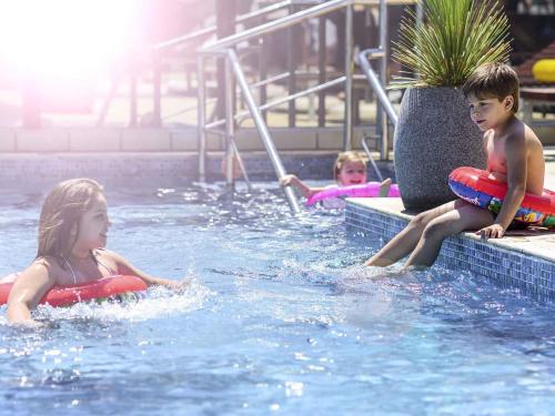 zwei Kinder spielen im Pool in der Unterkunft Novotel Florianopolis in Florianópolis